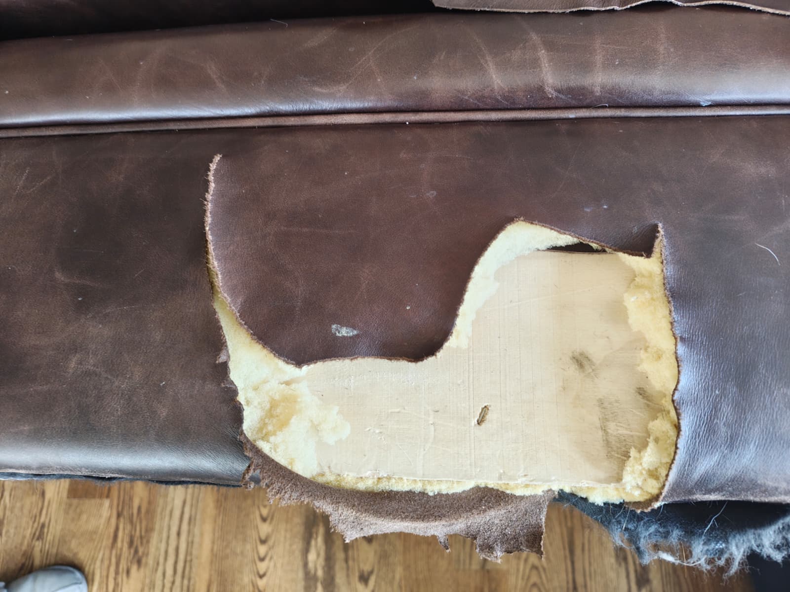 Damaged leather couch before restoration (left side)
